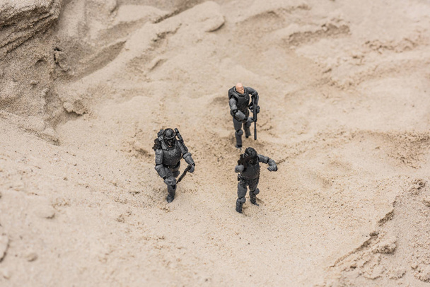 пластикові іграшкові солдати на піщаній дюні зі зброєю
 - Фото, зображення