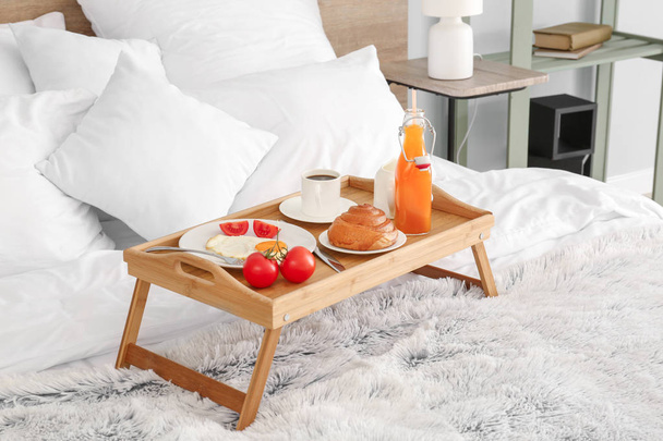 Table with tasty breakfast on bed - Foto, imagen