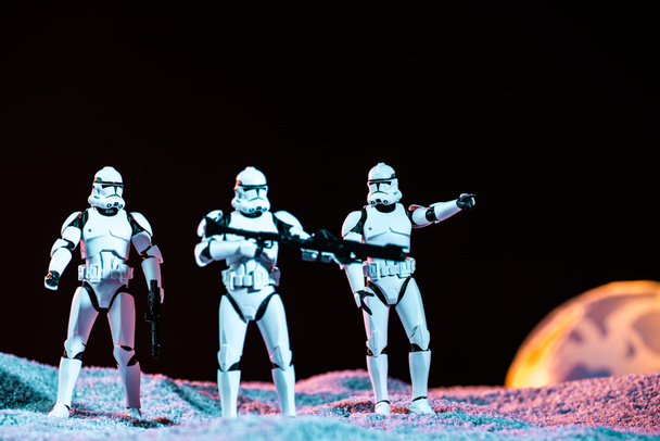 white imperial stormtroopers with weapon on cosmic planet isolated on black - Photo, image