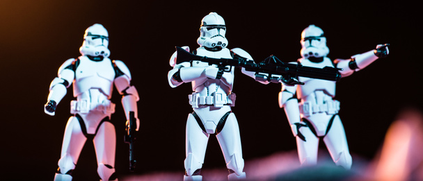 white plastic Imperial Stormtrooper with guns on black background - Fotoğraf, Görsel