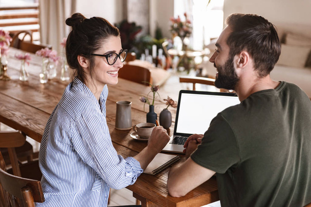 Image of caucasian brunette couple working on laptop together wh - Photo, image