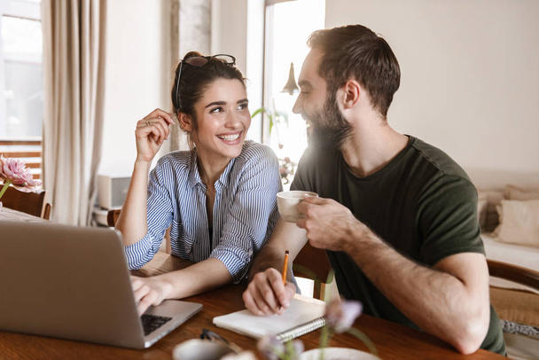 Image of successful brunette couple working on laptop together w - Photo, image