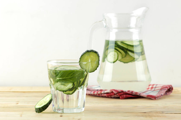 water with cucumber. Refreshing diet water with cucumber and mint in a glass beaker against a blue background. detox drink concept. summer refreshing drink. top view - Foto, Imagen