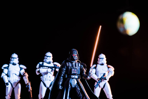 white imperial stormtroopers with guns and Darth Vader with lightsaber with planet Earth on background - Fotoğraf, Görsel