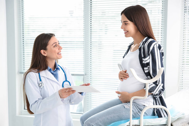 Female gynecologist working with pregnant woman in clinic - Фото, зображення