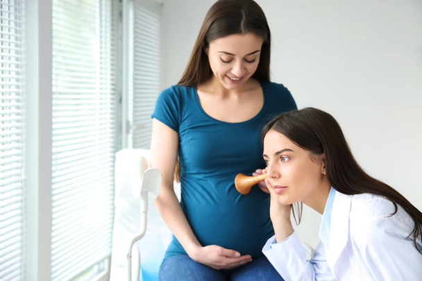 Γυναίκα γυναικολόγος που συνεργάζεται με έγκυο γυναίκα στην κλινική - Φωτογραφία, εικόνα