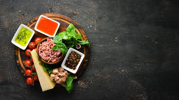 Ingredients for cooking sauce Bolognese. On a black background. Top view. Free space for your text. - Foto, imagen