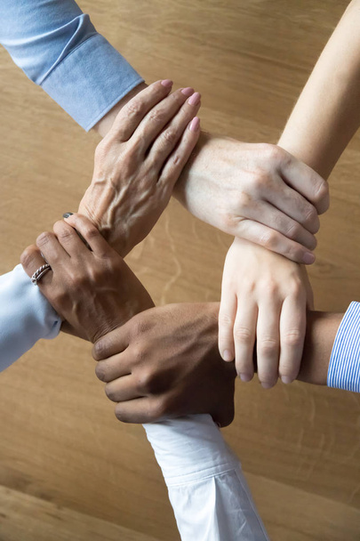 Close up multiracial business people holding each others wrists - Foto, immagini