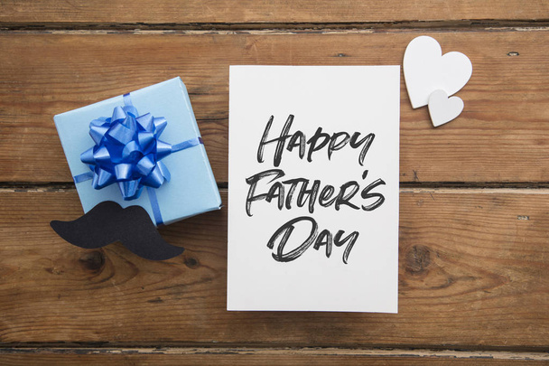 Happy Fathers Day card composition with gift box and mustache - Photo, Image