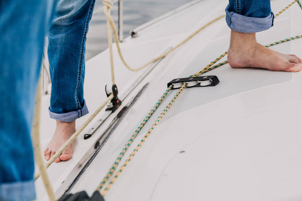 Bare feet stand on deck of  yacht - Fotoğraf, Görsel