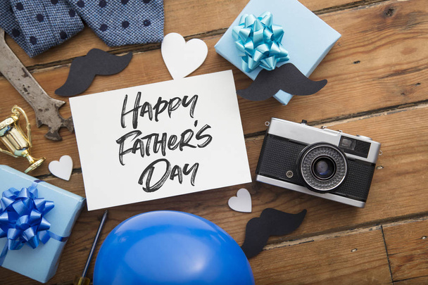 Happy Fathers day card composition with gifts, mustache, trophy, camera - Photo, Image