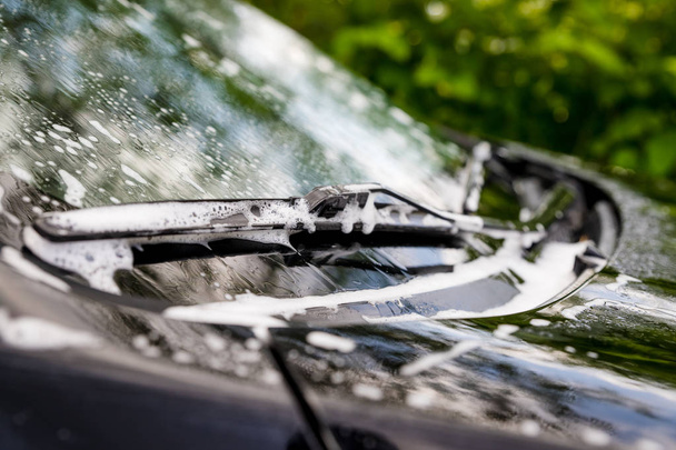 Outdoor car wash. Gentle Car Washing. Modern Car Covered by soap and Water. automobile, auto wash foam water,Auto detailing or valeting concept. Selective focus. - Photo, Image