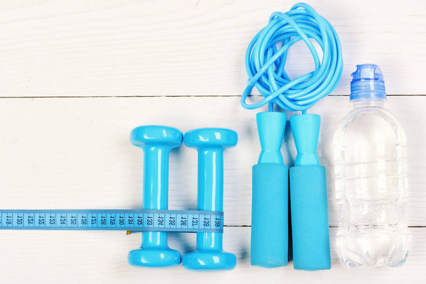 Gym tools on white backdrop. Sports equipment in cyan blue - Photo, image