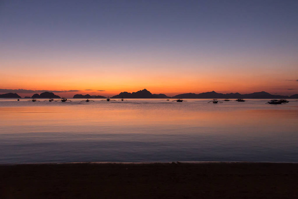 Silhuetas de barcos no porto tropical à noite. Pôr do sol na lagoa nas Filipinas, Palawan, El Nido. Pôr do sol na praia. Pôr-do-sol cênico com ilhas de montanhas no horizonte. Férias de verão e viagens. Paisagem exótica
.  - Foto, Imagem