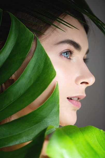Красивая женщина с идеальной кожей, покрытой зелеными листьями
. - Фото, изображение