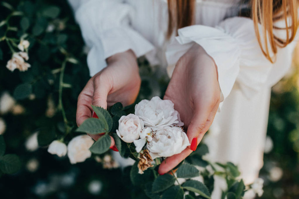 μερική θέα της γυναίκας και πανέμορφα λευκά τριαντάφυλλα - Φωτογραφία, εικόνα