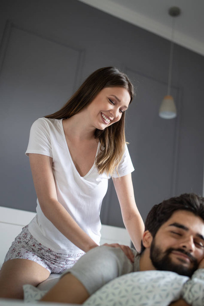 Young happy couple making massage in bedroom - Fotoğraf, Görsel