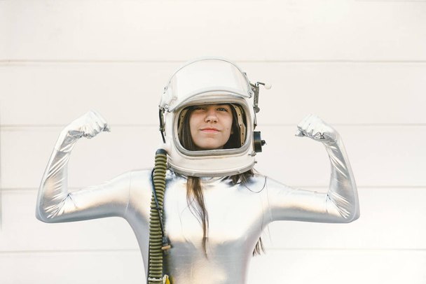 Girl in a silver suit and astronaut helmet - Fotoğraf, Görsel