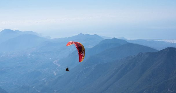 Paraglider flying over mountains - Fotoğraf, Görsel