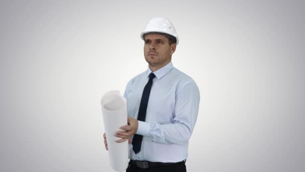 Engineer checking construction plan with what is built on gradient background. - Filmagem, Vídeo