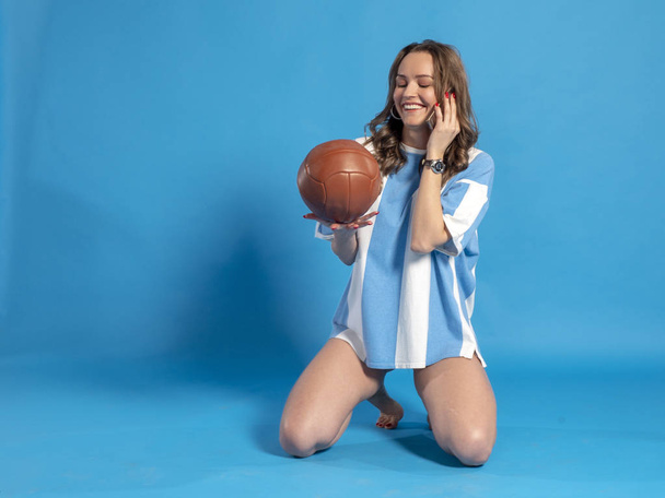 Girl in Argentina national football team shirt talking on the phone. - Fotoğraf, Görsel