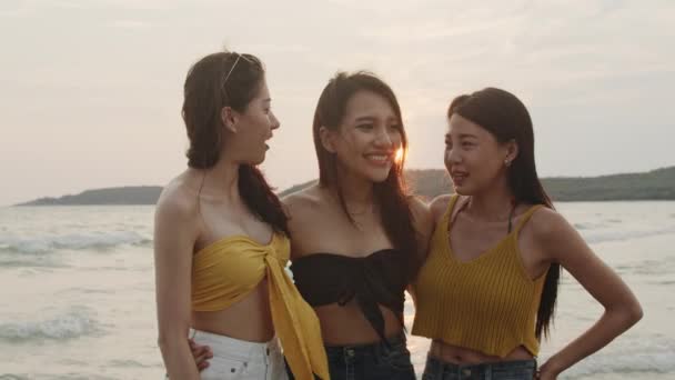 Groep Aziatische vrouwen praten samen genieten van grappig moment op het strand, mooie vrouwelijke ontspannen op het strand in de buurt van zee bij zonsondergang in de avond. Vrouw reizen op het strand in zomer concept. Slow Motion-opname. - Video