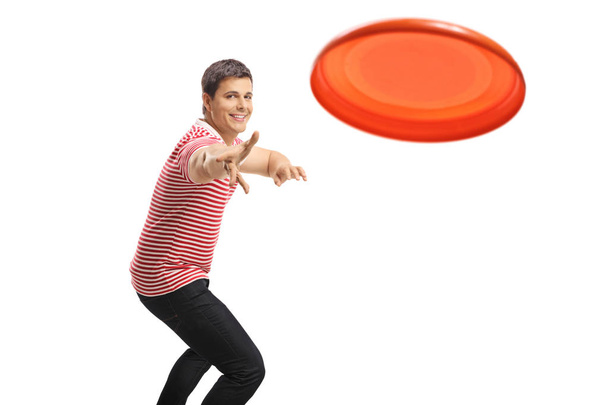 Young handsome guy throwing a frisbee - Φωτογραφία, εικόνα