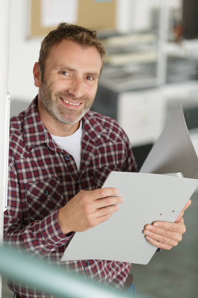 portrait of a male teacher holding a folder - Photo, image