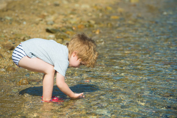Exploración del mar. Pequeño científico. El chico estudia el agua del mar. Turismo. Descanso verano
. - Foto, imagen