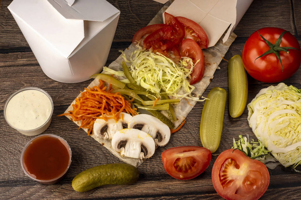 Fast food na wynos w pudełku na lunch z warzywami, sosem i pieczarkami - Zdjęcie, obraz
