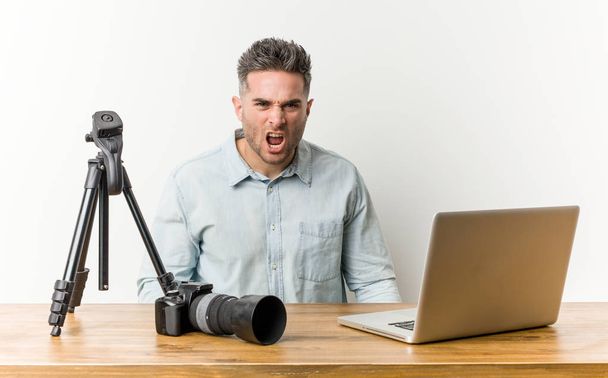 Young handsome photography teacher screaming very angry and aggressive. - 写真・画像