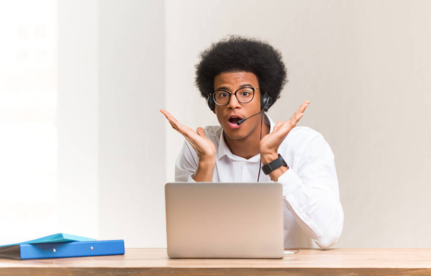 Young telemarketer black man surprised and shocked - Photo, Image