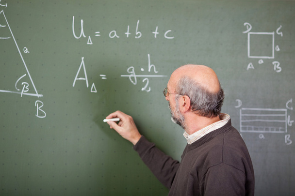 Teacher writes on blackboard - Valokuva, kuva