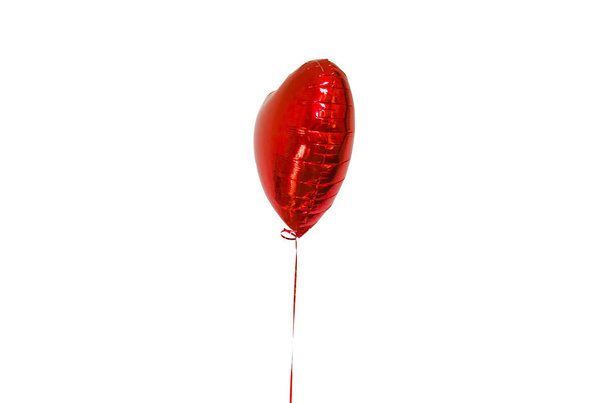 bola inflable en forma de corazón rojo, con una cuerda sobre un fondo blanco, aislar. el concepto de vacaciones, cumpleaños y amor
. - Foto, Imagen