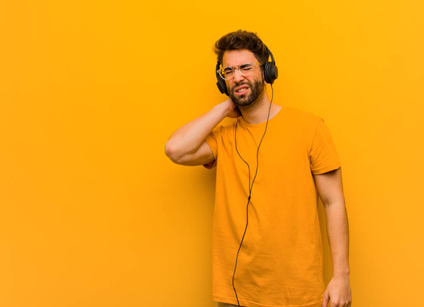 Giovane uomo che ascolta musica che soffre dolore al collo
 - Foto, immagini