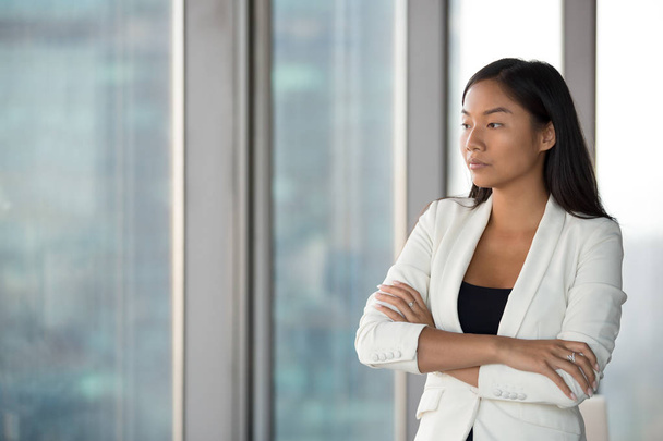 Pensive Asian female employee think of problem solution - Photo, Image