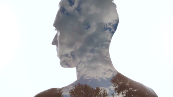 Portret van de peinzende man en wolken in de hemel-dubbele expositie - Video