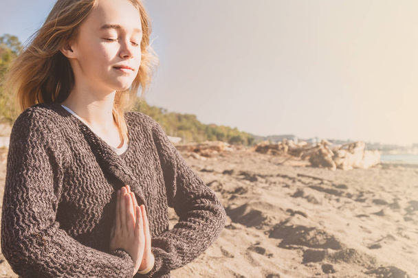 Onnellinen rento nuori nainen meditoi jooga aiheuttaa rannalla
 - Valokuva, kuva