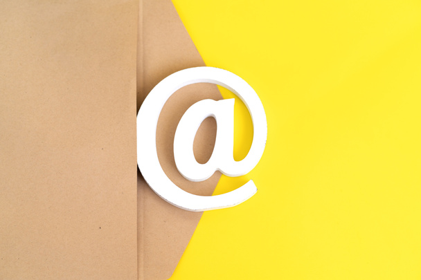 envelope marrom com sinal de e-mail no fundo amarelo
 - Foto, Imagem