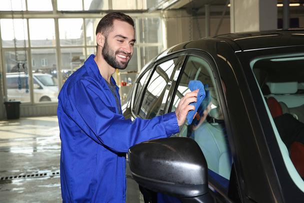 Worker cleaning automobile window with rag at car wash - Foto, Imagem