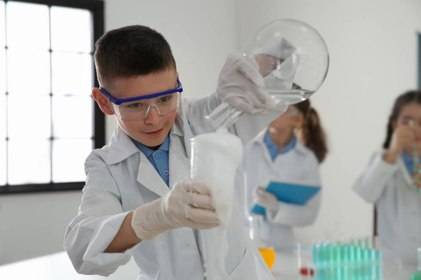Smart schoolboy making experiment in chemistry class - Photo, Image