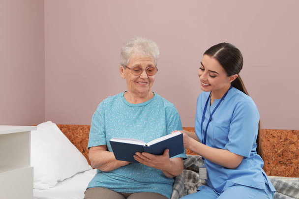 Nővér olvasatban könyvet vezető nő a kórházi osztályon. Orvosi segédkezés - Fotó, kép