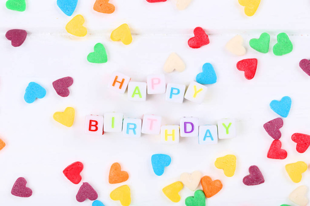 Text Herzlichen Glückwunsch zum Geburtstag durch Plastikwürfel mit Streusel in Form von  - Foto, Bild