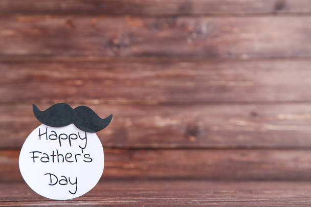 Text Happy Fathers Day with black mustache on wooden table - Photo, Image