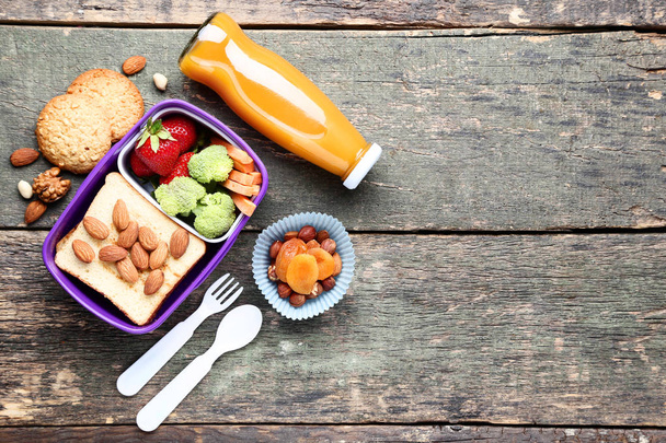 Koulun lounas laatikko vihanneksia ja pullo mehua puinen t
 - Valokuva, kuva