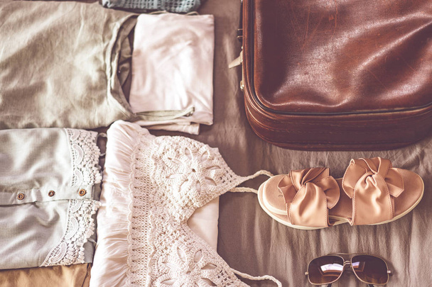 Roupas femininas de verão bem dobradas para serem embaladas em uma mala. Mala de viagem conceito de preparação
. - Foto, Imagem
