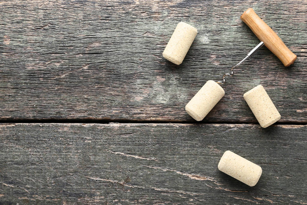 Wine corks with corkscrew on grey wooden table - Fotoğraf, Görsel