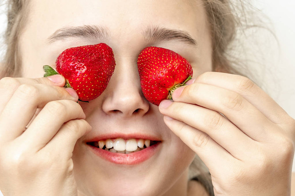 Strawberry Eyes . Beautiful young woman holding strawberries in eyes like binoculars. Healthy, lifestyle concept.  - Fotoğraf, Görsel