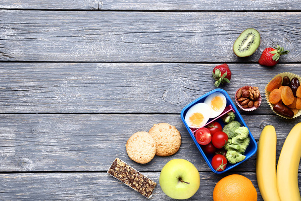 Iskolai ebéd-box a zöldségek és gyümölcsök a fa tábla - Fotó, kép