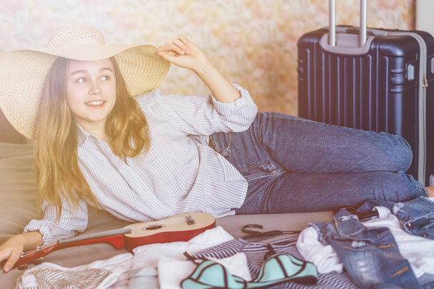 Viaggio estivo e concetto di vacanza. Giovane donna valigia di imballaggio a casa
 - Foto, immagini